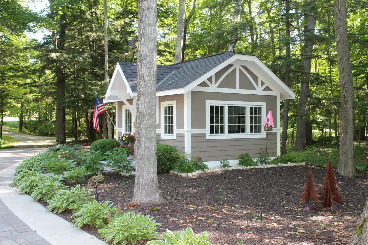 Small cottage with American flag in wooded landscape