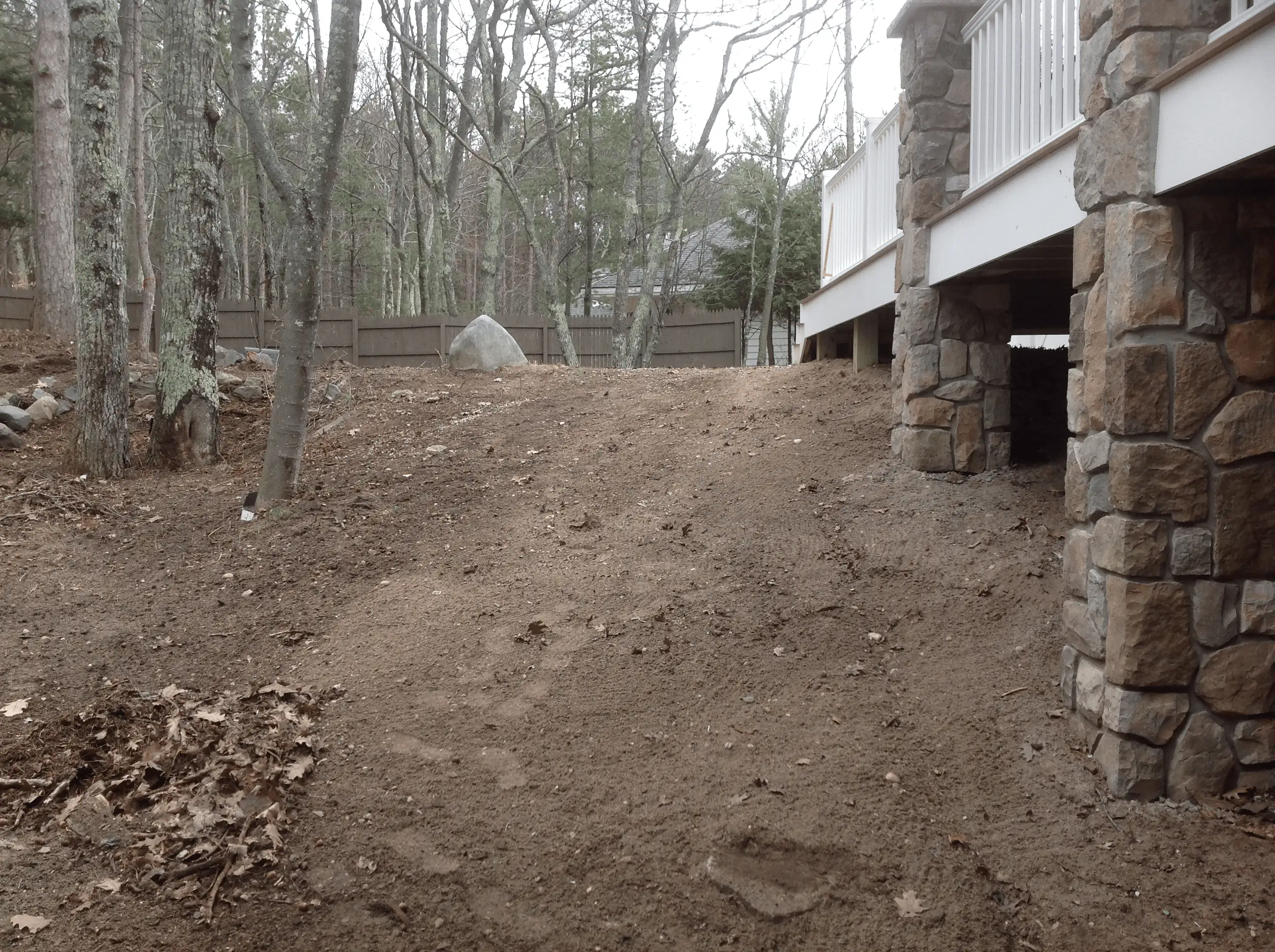 Before: sloped area before dry creekbed and steps were installed.